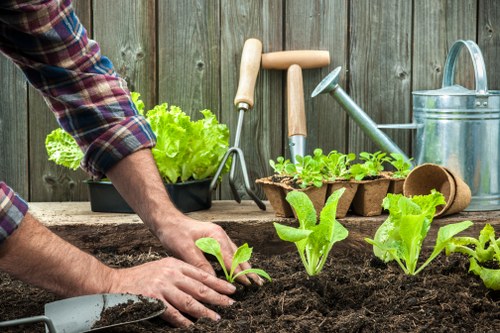 Gardener working in a Catford front garden with tools